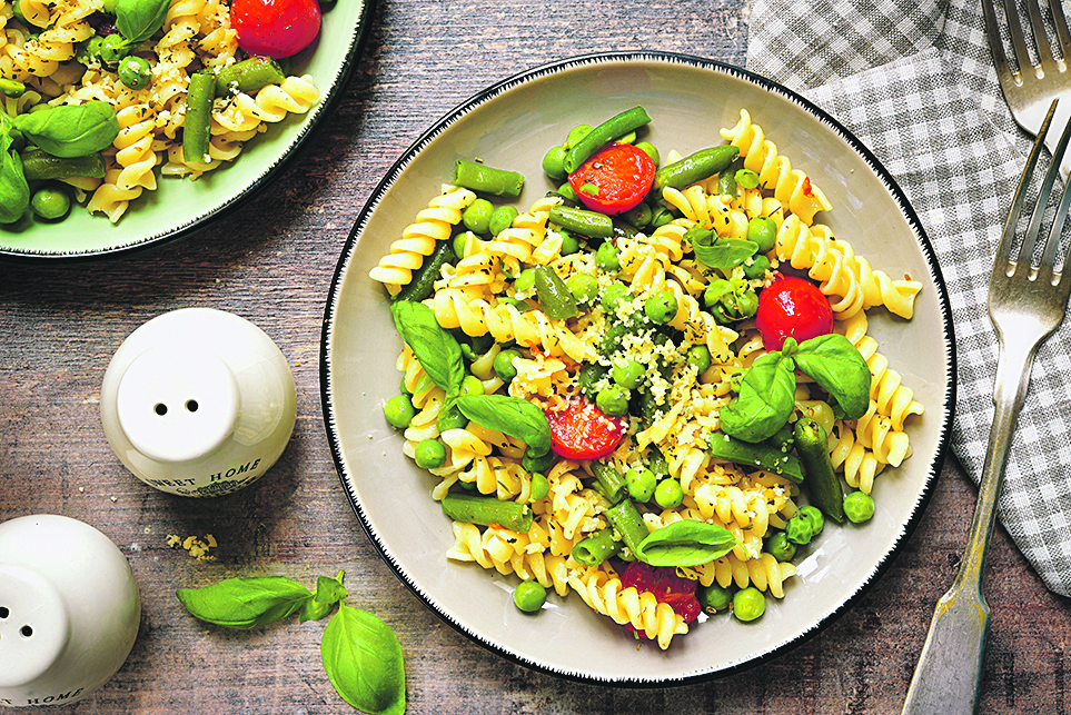 Pasta primavera on a vintage plates on wooden background.