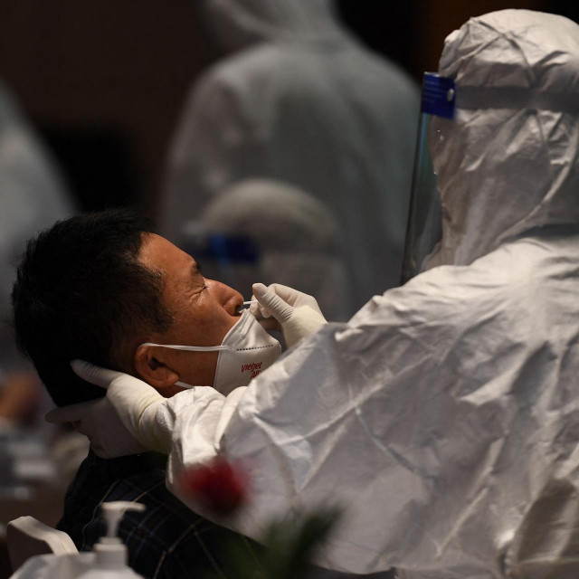 A medical worker takes a test sample for the Covid-19 virus from a South Korean tourist on Phu Quoc island on November 20, 2021, as the island welcomes its first international tourists to arrive after a Covid-19 coronavirus vaccine passport scheme kicked off this month in Vietnam. (Photo by Nhac NGUYEN/AFP)
